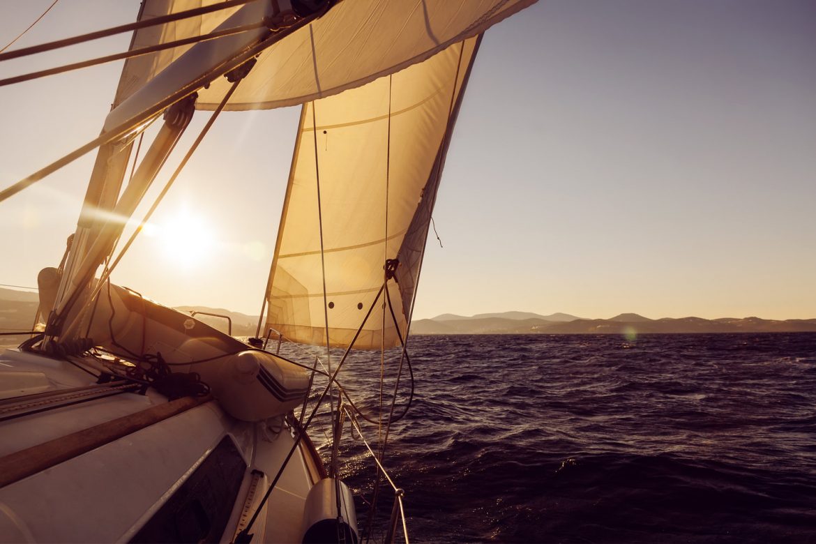 Sailboat crop during the regatta at sunset ocean.